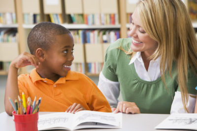 Teacher-with-boy-and-book-smiling